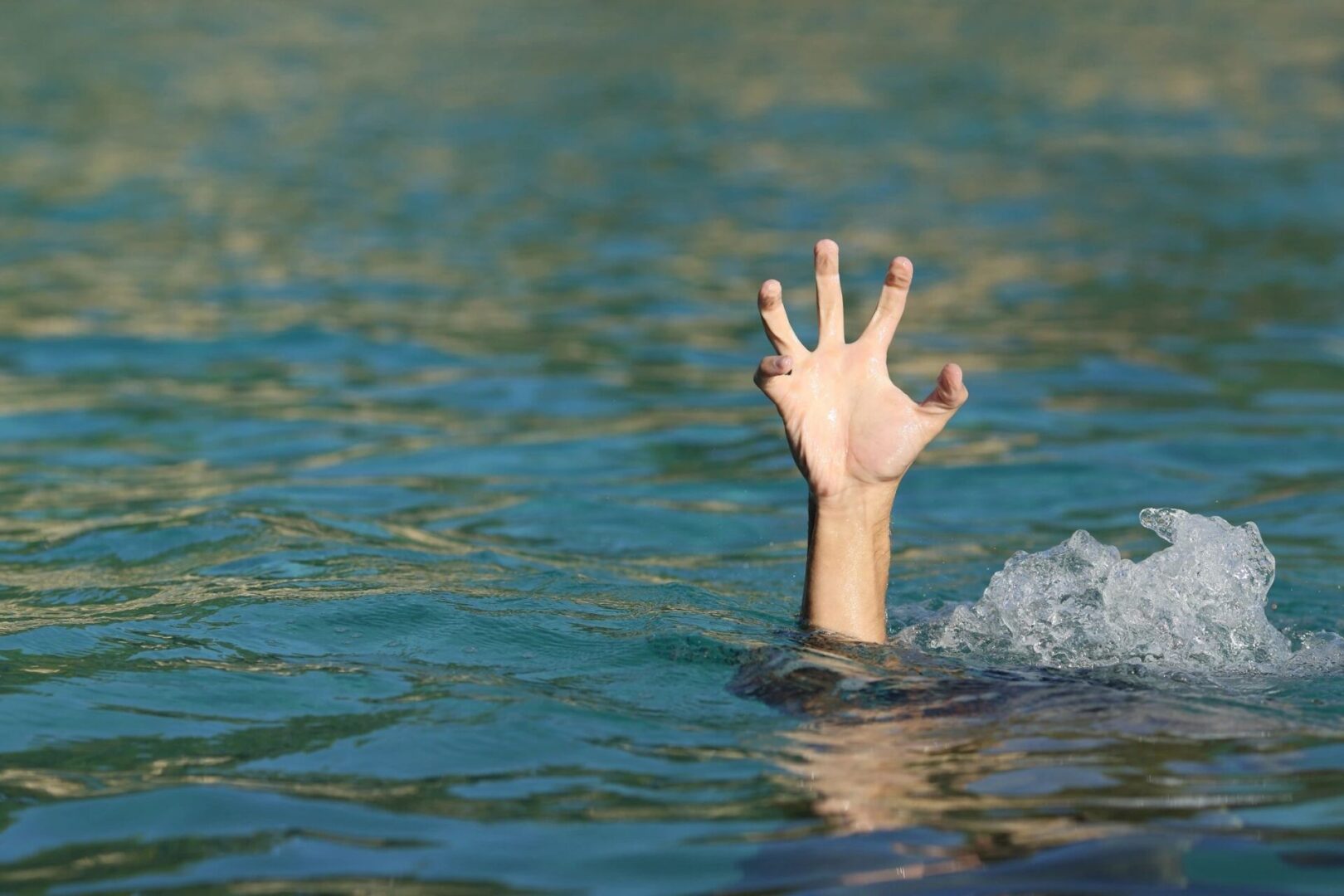A hand is reaching out of the water.